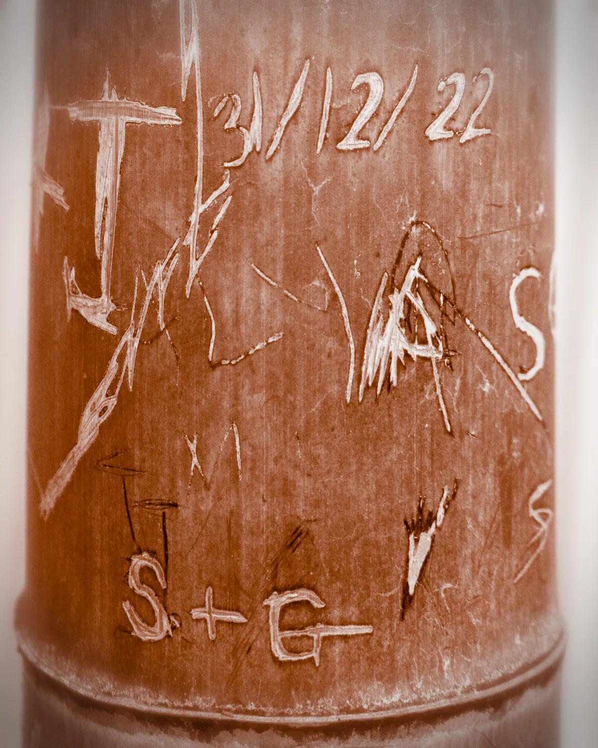 A sepia photo of a closeup of carvings on a bamboo stalk