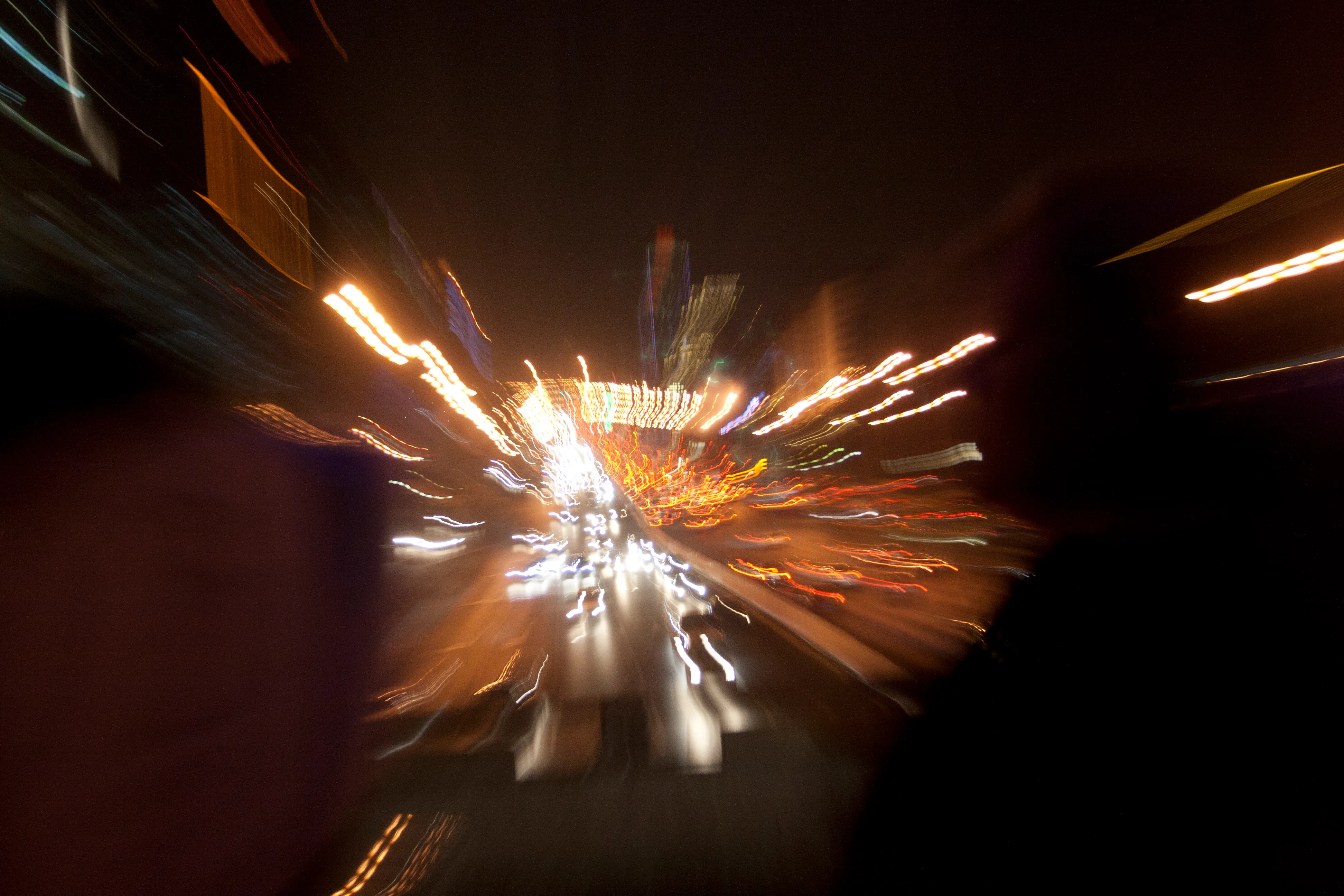Night traffic on a Beijing roadway rendered as bright streaks by zooming during a slow exposure.