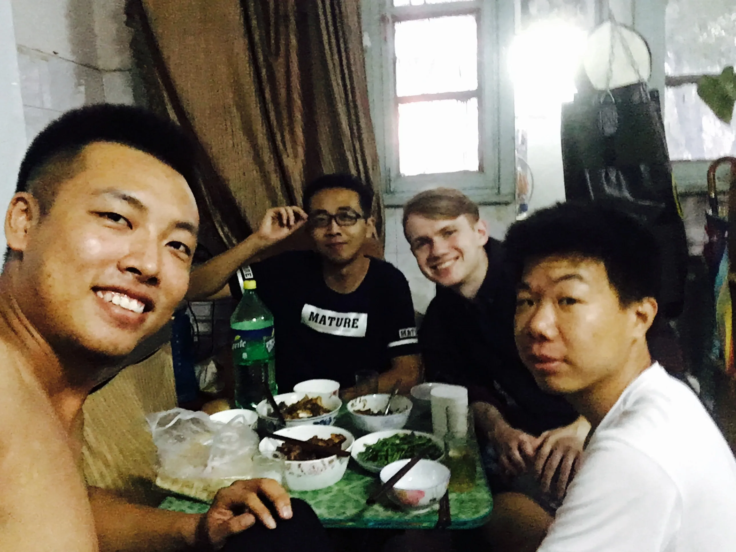 Four friends eating together at a small table.