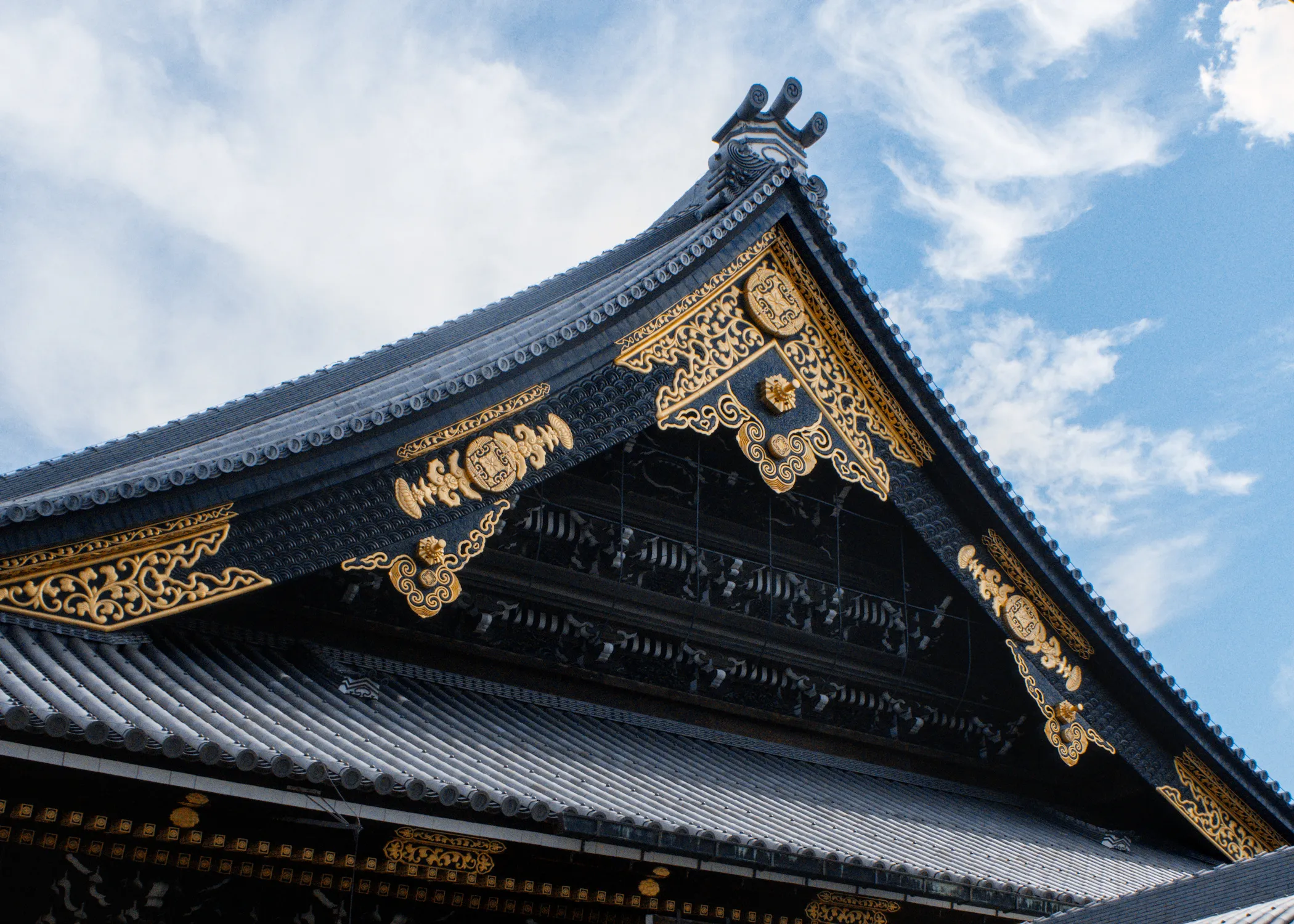 Ornate temple roof with gold detailing against a blue sky
